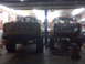 1994 Ford F-250 - Two pickup trucks are parked side-by-side in a garage, one yellow and one red.