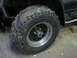 1971 International Travelall - Muddy ATV tire and wheel assembly in a garage setting.