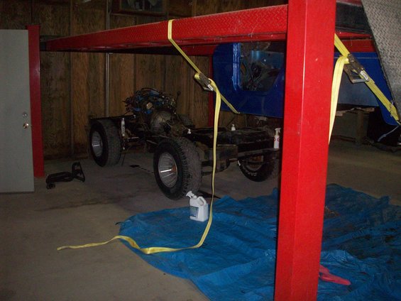 1978 Jeep CJ5 chassis with engine and drivetrain suspended on a lift
