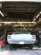 1969 Ford Torino - The rear of a classic car is parked in a garage, with shelves of supplies visible in the background.