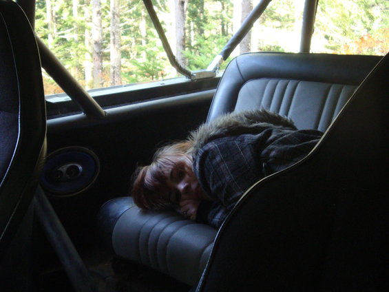 Interior view of a vehicle with a person sleeping on the seat