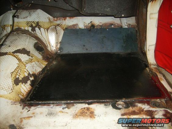 Interior floor pan with metal patch and rust damage