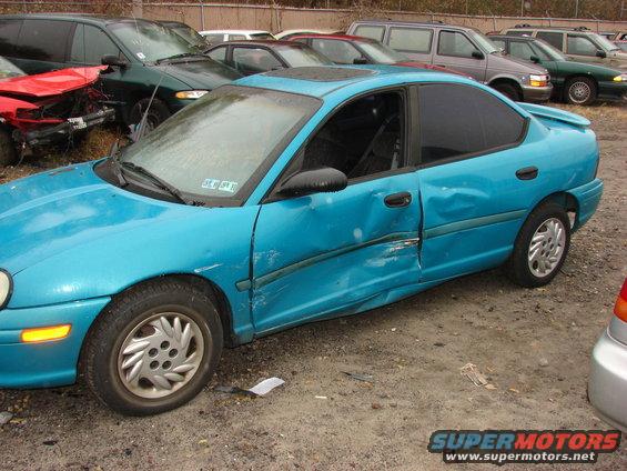 Blue sedan with significant side damage, viewed from the side