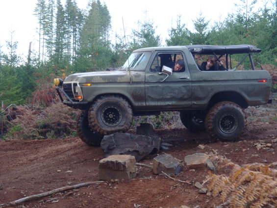 1978 Ford Bronco with off-road tires and custom bumper on a dirt trail