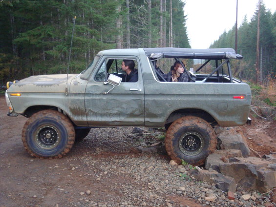 1978 Ford Bronco with soft top, driving over rocks on a dirt trail