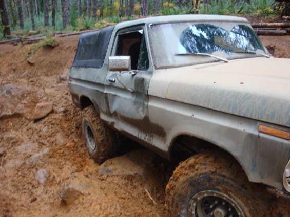 Muddy 1978 Ford Bronco on rocky, off-road trail
