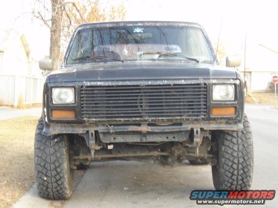Front view of black SUV with large tires and aftermarket grille