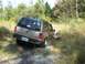 1992 Ford Explorer - A 1992 Ford Explorer navigates a dirt path surrounded by tall grass and trees.