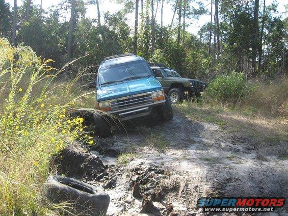 Teal 1992 Ford Explorer on muddy trail with another SUV behind it