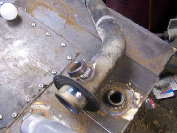 close-up of a custom fuel tank with welded fittings and a rubber gasket