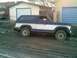 1985 Ford Bronco - This two-tone Ford Bronco is seen from the side, stuck in muddy terrain.