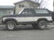 1985 Ford Bronco - This two-tone Ford Bronco is shown from the side, a black roof and white lower body panels.