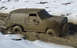 1985 Ford Bronco - Muddy 1985 Ford Bronco struggling through a treacherous, snow-dusted mire.