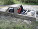 1985 Ford Bronco - This SUV is deeply stuck in mud, with its interior and cargo area partially submerged.