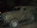 1985 Ford Bronco - This heavily mud-caked SUV, likely from the early to mid-1980s, is viewed from the front three-quarter angle.