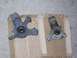 1999 Volkswagen Beetle - Two automotive steering knuckles are shown, one in gray and the other in black, placed on a cardboard surface.