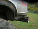 1991 Ford F-150 - The rear of a silver 1991 Ford F-150 pickup truck is visible, showing a 4x4 decal and a black bumper.