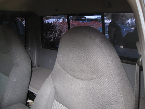 Gray fabric seats in a truck cab, looking towards the rear window