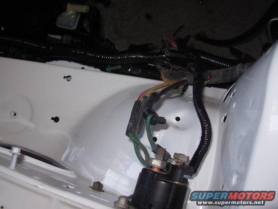 Automotive starter relay with green and yellow wires connected, white fender well