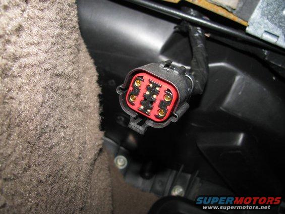 Close-up of a red and black electrical connector with gold pins