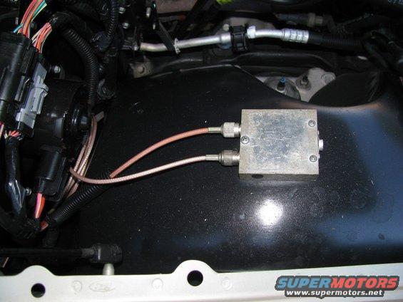 In the engine bay, on the passenger side fender.