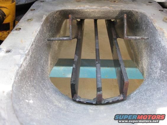Jet pump intake grate with metal bars and a rough aluminum housing