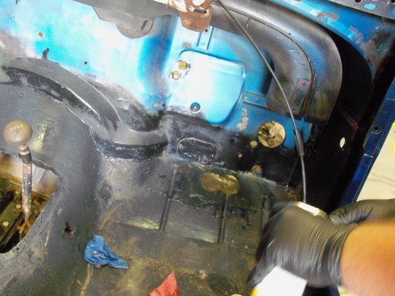 Close-up of a vehicle's interior floor pan with a gear shift lever visible