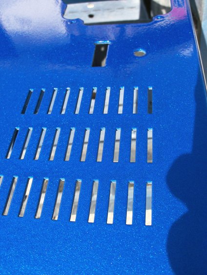 blue painted metal panel with rows of rectangular slots