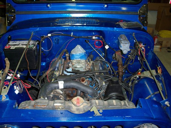 Blue 1978 Jeep CJ5 engine bay with carburetor, battery, and wiring visible