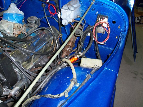 Blue Jeep engine bay with visible carburetor and wiring