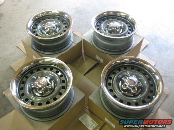 Four steel wheels with chrome trim rings, each sitting on a cardboard box