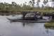 1993 Ford Bronco - A 1993 Ford Bronco navigates a muddy water obstacle with another truck visible in the background.