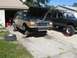 1992 Ford Explorer - A two-tone 1992 Ford Explorer is undergoing repairs in a driveway, with its front end dismantled and a Jeep Cherokee parked nearby.