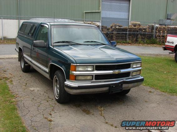 Green 1995 Chevrolet C/K pickup truck with camper shell, 3q-front view