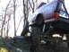 1994 Ford F-250 - A red pickup truck navigates a rocky, off-road trail with one tire lifted high.