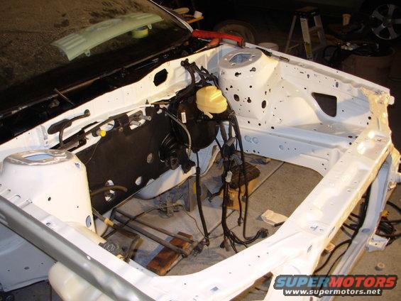 car's engine bay, white painted frame, brake booster, wiring harness