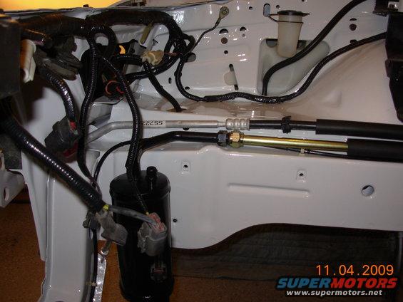 engine bay with wiring harnesses and metal hoses