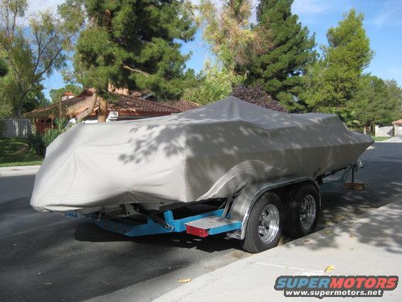 Boat on trailer covered by a tarp, side view