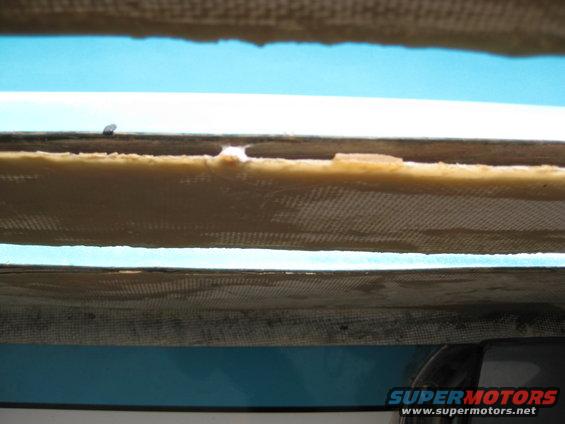 Boat hull interior showing layered fiberglass and foam construction with a blue exterior visible below