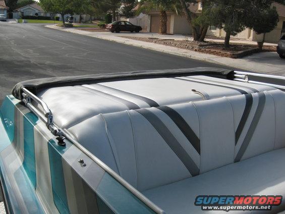Boat interior with gray and white striped seats and a black cover