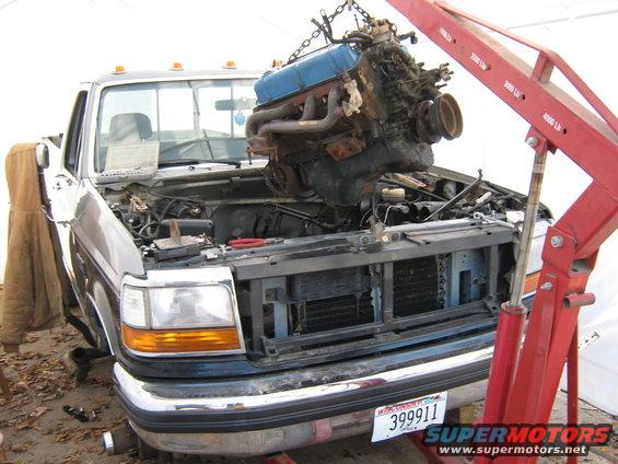 1992 Ford F-250 engine bay with engine being lifted by a red engine hoist