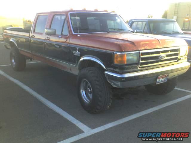 Red and black 1990 Ford F-350 crew cab pickup truck, front 3/4 view