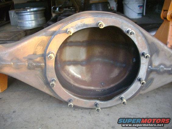 Close-up of a rear axle differential housing with bolts around the cover opening. Some welding is visible on the housing