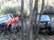 1994 Ford F-250 - Two modified trucks navigate a muddy stream bed surrounded by trees, with the red Ford F-250 on the left and a black Jeep on the right.