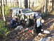 1994 Ford F-250 - A group of people are gathered around a modified Jeep Cherokee in a wooded area, appearing to perform maintenance.