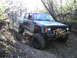 1994 Ford F-250 - Modified Jeep Cherokee navigates a steep, wooded off-road trail.