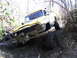 1994 Ford F-250 - This Jeep is navigating a challenging off-road trail with steep inclines and muddy terrain.