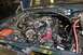 1996 Ford Bronco - The engine bay of a 1996 Ford Bronco shows its V8 engine, battery, and various hoses and wires.