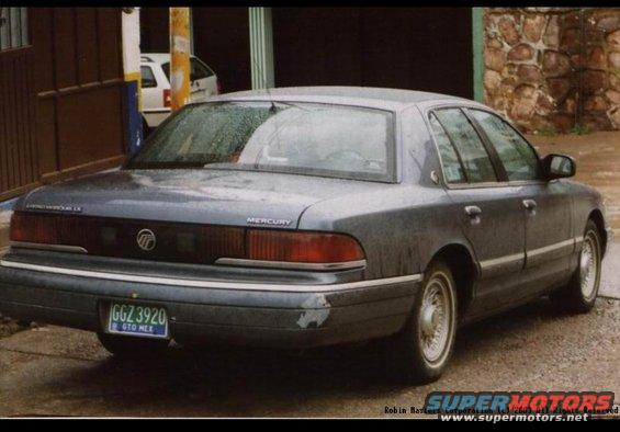 Dark gray 1992 Mercury Grand Marquis sedan, rear 3/4 view, showing damage on rear bumper