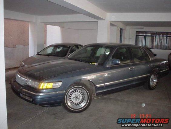 1992 Mercury Grand Marquis parked next to a dark sedan in a garage